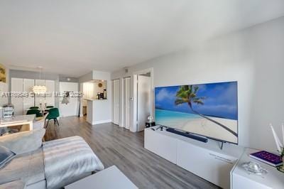 living area with wood finished floors and a notable chandelier