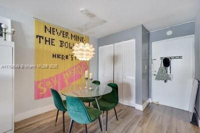 dining space with baseboards and wood finished floors