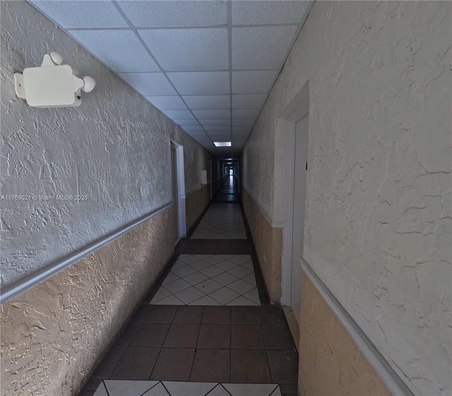 5775 W 20th Ave Unit 107, Hialeah, FL 33012 - hallway with tile patterned floors, a textured wall, and a paneled ceiling