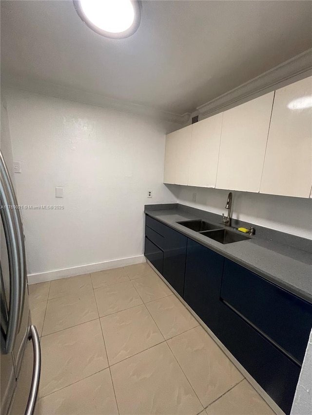 5775 W 20th Ave Unit 107, Hialeah, FL 33012 - kitchen featuring a sink, white cabinetry, light tile patterned flooring, baseboards, and crown molding