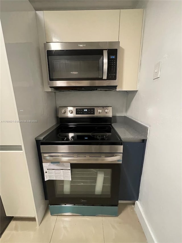 5775 W 20th Ave Unit 107, Hialeah, FL 33012 - kitchen with appliances with stainless steel finishes, baseboards, and white cabinetry