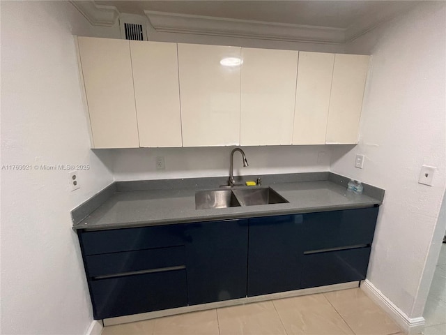 5775 W 20th Ave Unit 107, Hialeah, FL 33012 - kitchen featuring a sink, crown molding, baseboards, and white cabinets