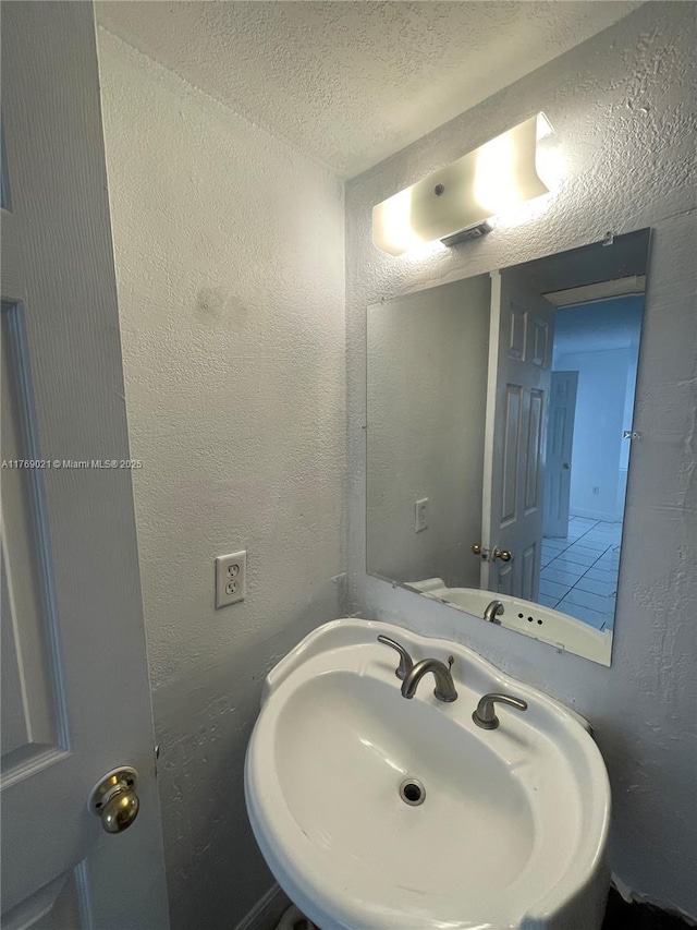 5775 W 20th Ave Unit 107, Hialeah, FL 33012 - bathroom featuring a sink, a textured wall, and a textured ceiling