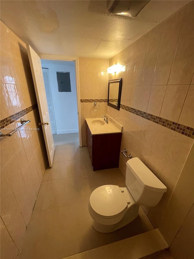 5775 W 20th Ave Unit 107, Hialeah, FL 33012 - half bathroom featuring tile walls, vanity, toilet, and tile patterned flooring
