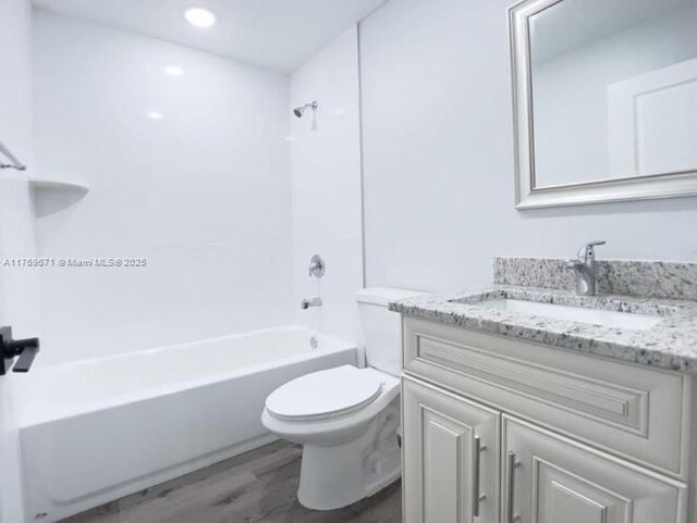 bathroom with vanity, recessed lighting, toilet, shower / washtub combination, and wood finished floors