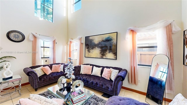 tiled living room with baseboards, a wealth of natural light, and a high ceiling