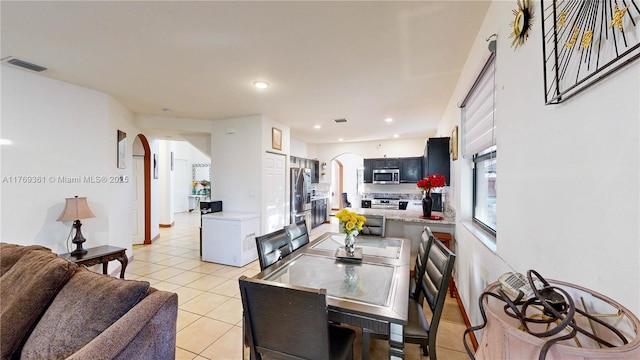 dining space featuring light tile patterned flooring, arched walkways, recessed lighting, and visible vents