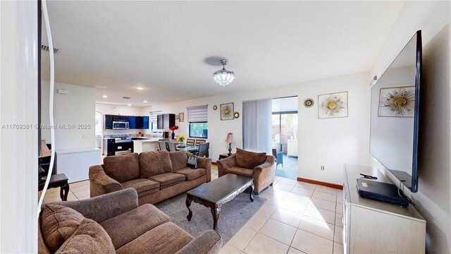 living area featuring light tile patterned flooring, baseboards, a chandelier, and recessed lighting