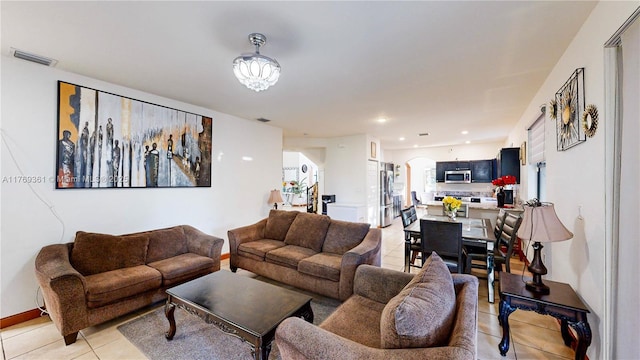 living area featuring a chandelier, light tile patterned floors, visible vents, arched walkways, and recessed lighting