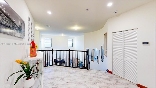 hall with marble finish floor, visible vents, an upstairs landing, and recessed lighting