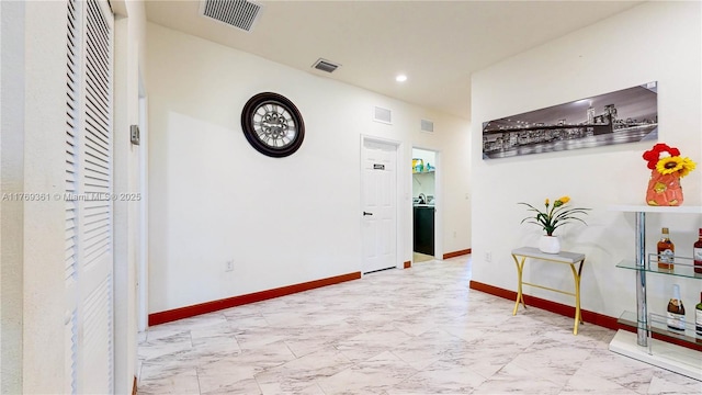 hall with marble finish floor, recessed lighting, baseboards, and visible vents