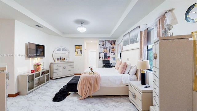 bedroom featuring marble finish floor, a tray ceiling, and visible vents