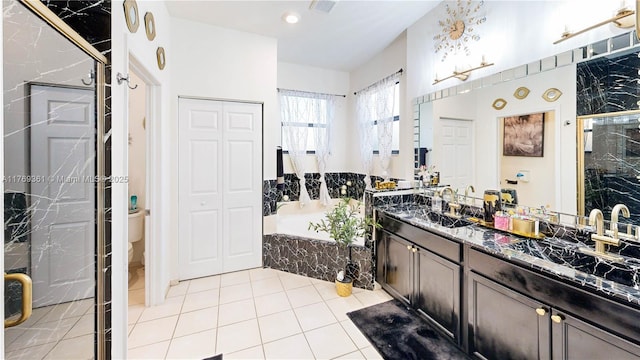 bathroom with a closet, a garden tub, tile patterned flooring, visible vents, and double vanity