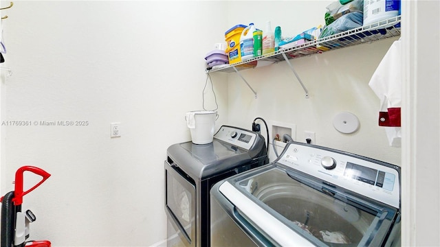 clothes washing area featuring separate washer and dryer and laundry area