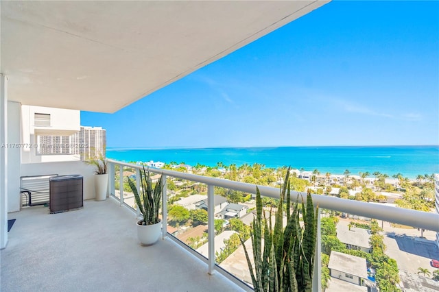 balcony with a water view and a view of the beach