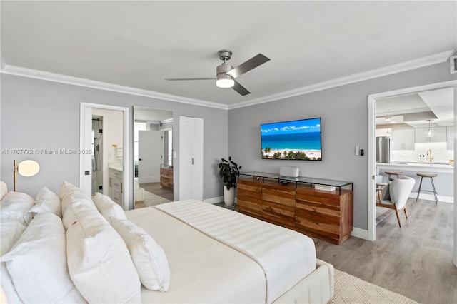 bedroom with a sink, ensuite bath, ornamental molding, and wood finished floors