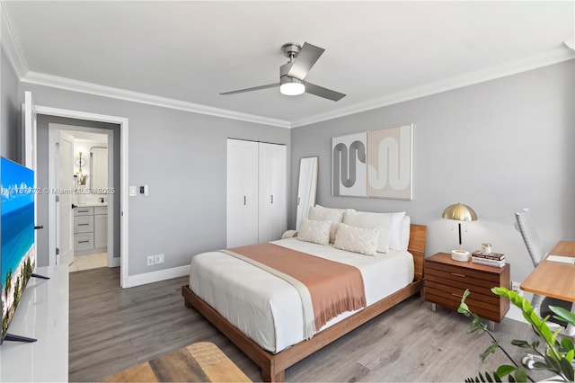 bedroom featuring baseboards, crown molding, and wood finished floors
