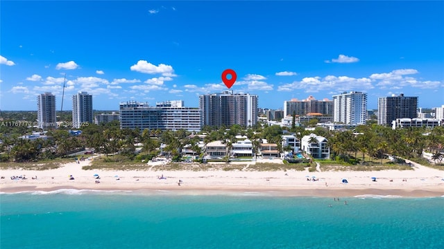drone / aerial view featuring a view of the beach, a water view, and a view of city