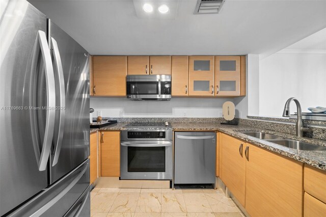 2101 Brickell Ave Unit 1809, Miami, FL 33129 - kitchen featuring stainless steel appliances, a sink, dark stone countertops, light marble finish floors, and ornamental molding