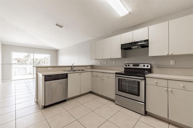 kitchen with light countertops, under cabinet range hood, a sink, visible vents, and appliances with stainless steel finishes