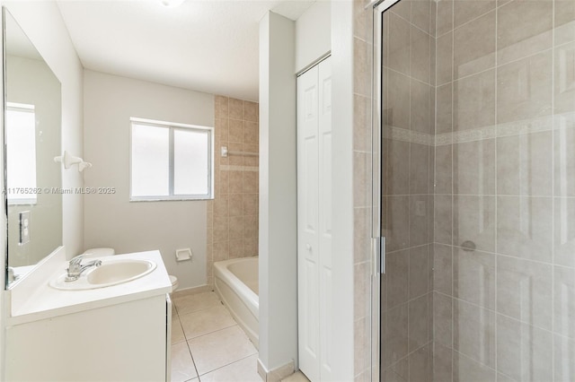 bathroom featuring tile patterned floors, a tile shower, toilet, a tub to relax in, and vanity