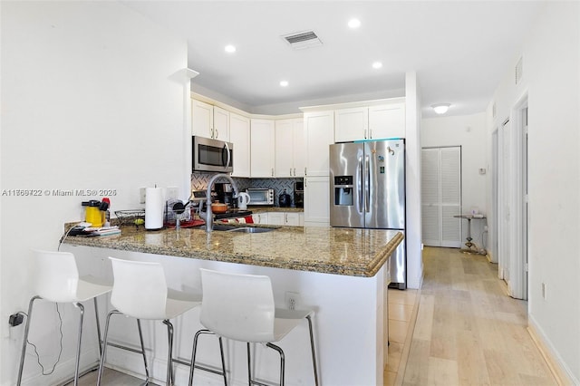 3340 Palomino Dr Unit 221-2, Davie, FL 33024 - kitchen with stainless steel appliances, a peninsula, a sink, backsplash, and light wood finished floors