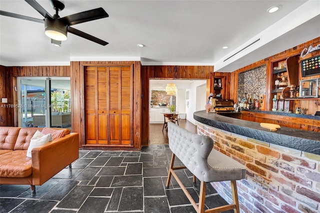 3407 N Longfellow Cir, Hollywood, FL 33021 - indoor wet bar featuring dark stone finish floors, wooden walls, ceiling fan, and recessed lighting