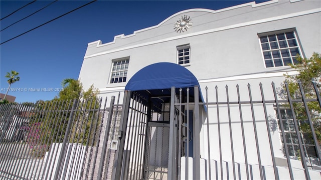 exterior space featuring stucco siding and fence