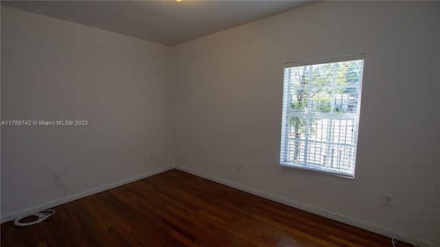 empty room with baseboards and wood finished floors