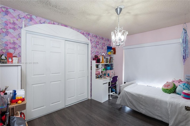 9137 Limetree Ln Unit 166, Pembroke Pines, FL 33024 - bedroom with wallpapered walls, dark wood-type flooring, a chandelier, a textured ceiling, and a closet