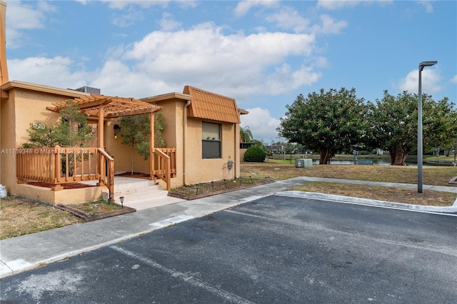 9137 Limetree Ln Unit 166, Pembroke Pines, FL 33024 - view of front of home with a pergola, stucco siding, and uncovered parking