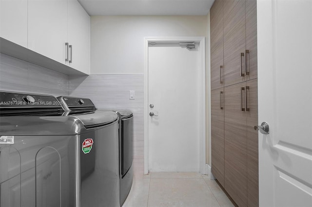 2541 Golf View Dr, Weston, FL 33327 - laundry room featuring cabinet space, washer and dryer, light tile patterned floors, and tile walls