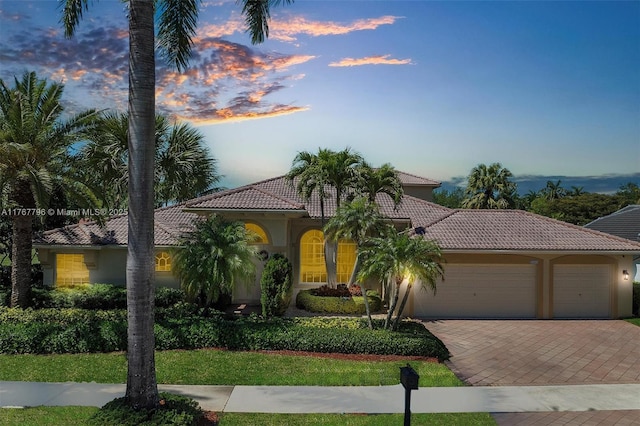 2541 Golf View Dr, Weston, FL 33327 - mediterranean / spanish-style home with an attached garage, a tiled roof, driveway, and stucco siding