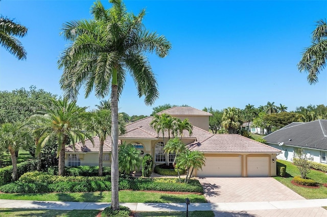 2541 Golf View Dr, Weston, FL 33327 - mediterranean / spanish-style house featuring a tiled roof, stucco siding, a garage, and decorative driveway