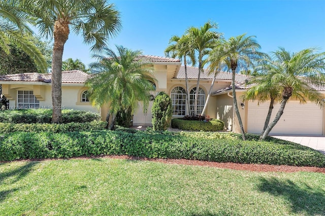 2541 Golf View Dr, Weston, FL 33327 - mediterranean / spanish-style house with stucco siding, a tiled roof, a front lawn, and a garage