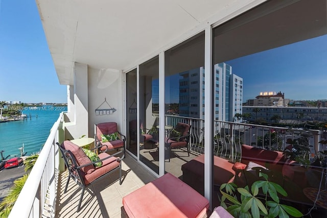 balcony featuring a water view and a city view