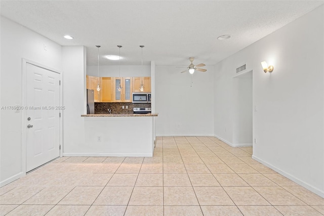 915 NE 199th St Unit 202-15, Miami, FL 33179 - kitchen featuring visible vents, a peninsula, stainless steel appliances, a ceiling fan, and tasteful backsplash