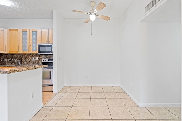 915 NE 199th St Unit 202-15, Miami, FL 33179 - kitchen with stainless steel appliances, a ceiling fan, glass insert cabinets, backsplash, and light tile patterned floors