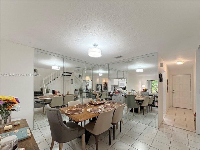 4306 N Carambola Cir N, Coconut Creek, FL 33066 - dining room featuring stairs, light tile patterned floors, and a textured ceiling