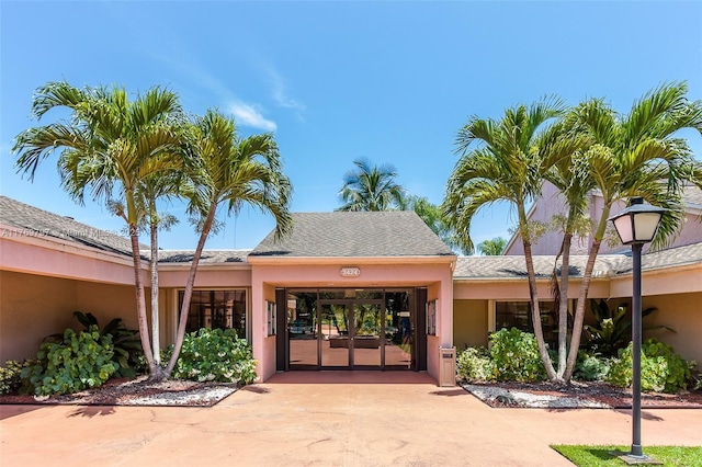 4306 N Carambola Cir N, Coconut Creek, FL 33066 - doorway to property featuring driveway and stucco siding