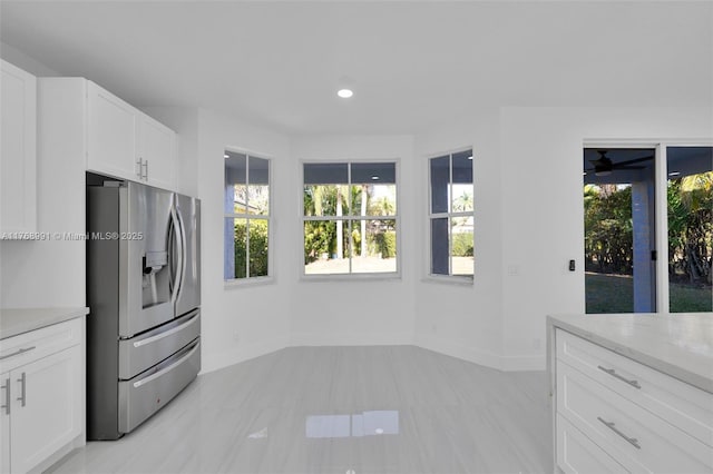1170 Chenille Cir, Weston, FL 33327 - kitchen with stainless steel fridge with ice dispenser, baseboards, white cabinetry, light stone counters, and recessed lighting
