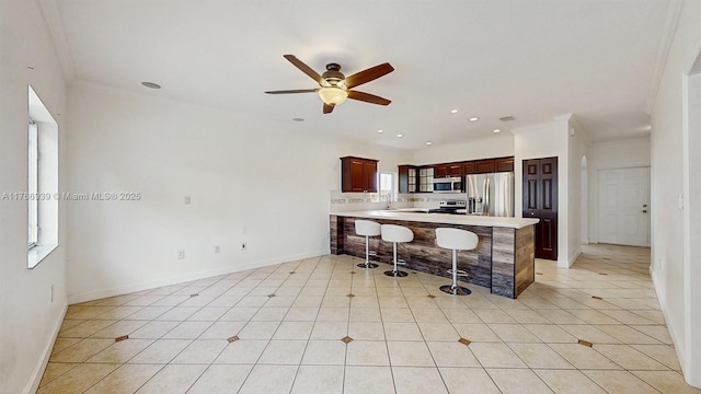 14214 SW 129th Path, Miami, FL 33186 - kitchen with appliances with stainless steel finishes, a peninsula, ceiling fan, a breakfast bar, and light countertops