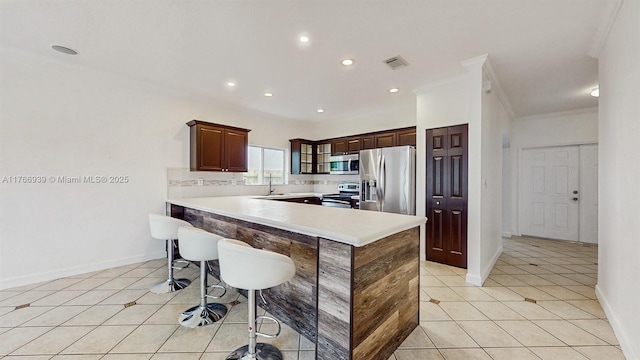 14214 SW 129th Path, Miami, FL 33186 - kitchen featuring stainless steel appliances, light tile patterned floors, a breakfast bar area, light countertops, and a sink