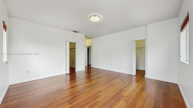 14214 SW 129th Path, Miami, FL 33186 - unfurnished bedroom featuring a walk in closet, light wood finished floors, baseboards, and a closet