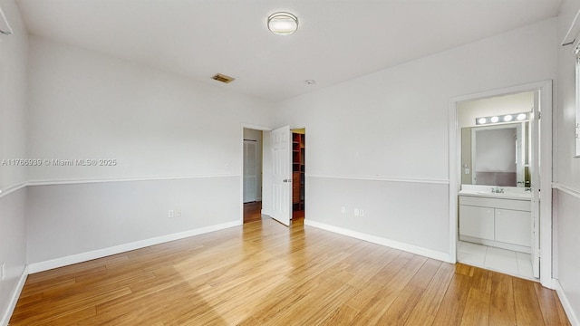 14214 SW 129th Path, Miami, FL 33186 - unfurnished bedroom with light wood-style floors, a sink, baseboards, and connected bathroom