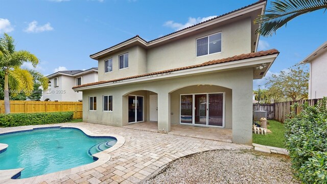 14214 SW 129th Path, Miami, FL 33186 - back of property featuring stucco siding, a patio area, and a fenced backyard