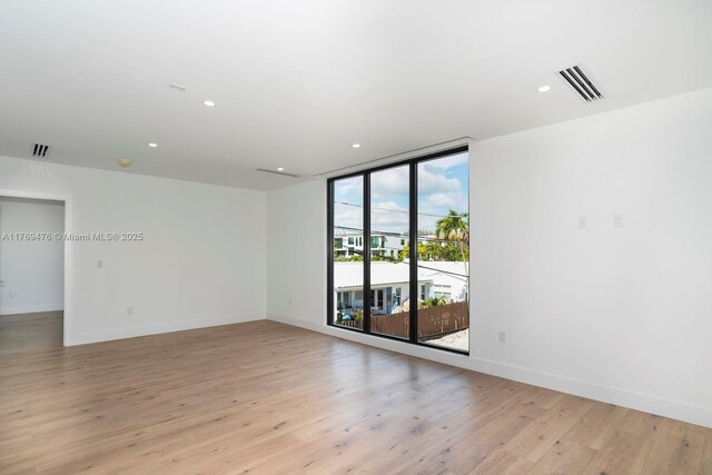 1635 E Broward Blvd, Fort Lauderdale, FL 33301 - empty room featuring light wood-style flooring, recessed lighting, baseboards, and a wall of windows