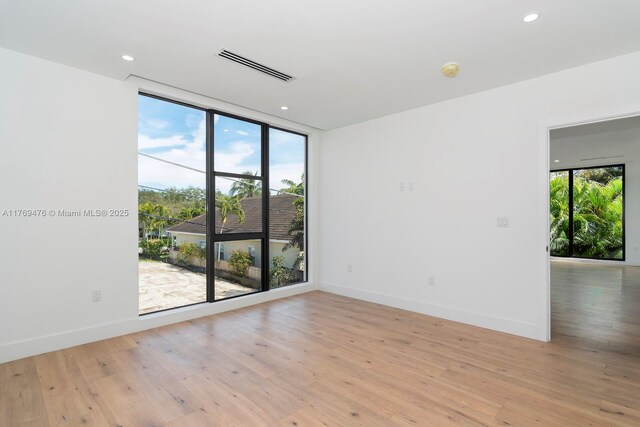 1635 E Broward Blvd, Fort Lauderdale, FL 33301 - spare room featuring expansive windows, baseboards, light wood-style flooring, and recessed lighting