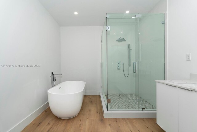 1635 E Broward Blvd, Fort Lauderdale, FL 33301 - bathroom with a stall shower, wood finished floors, baseboards, a soaking tub, and vanity