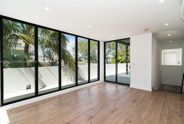 1635 E Broward Blvd, Fort Lauderdale, FL 33301 - empty room featuring wood finished floors, recessed lighting, and a wall of windows